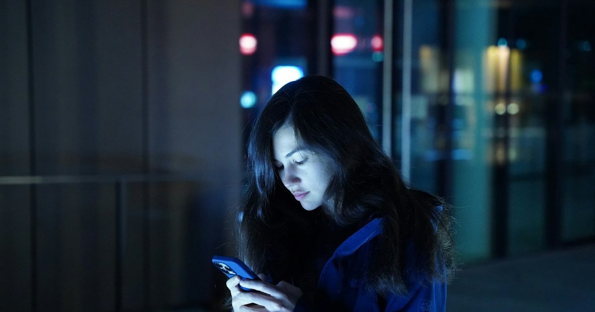 A person reading messages on a phone at night